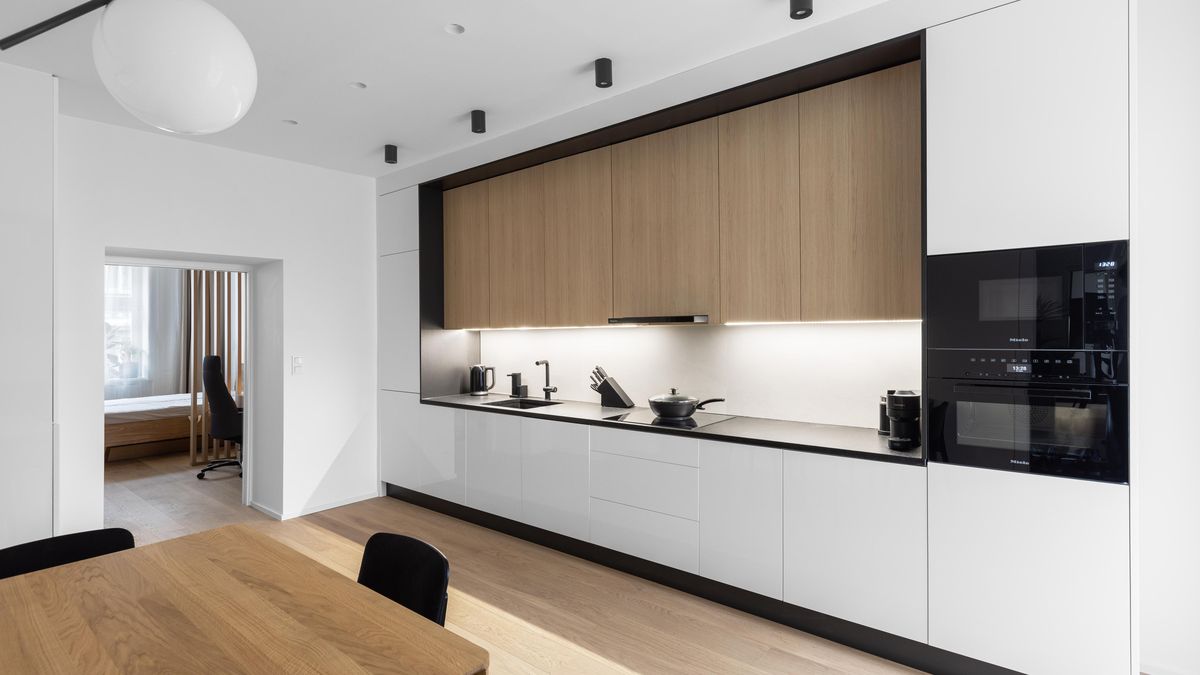 V žižkovském bytě rozehrála architektka elegantní kompozici černé, bílé a dřeva