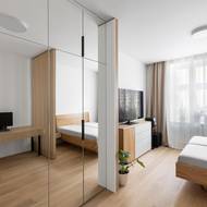 U vstupu, naproti pracovnímu stolu, je velká zrcadlová šatní skříň.