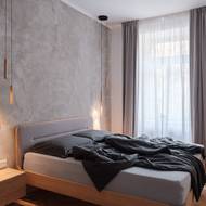 Za čelem lůžka v ložnici je na stěně použita jemná stěrka.