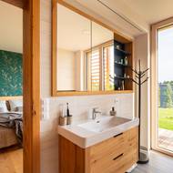 Koupelnu krášlí světlé dřevo. 