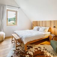 Interiér je naditý spoustou pěkných nápadů. V ložnici stojí za pozornost hezky řešený panel za čelem postele. Ze strany je využitý i jako úložný prostor.