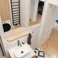 Polička se zaoblenými rohy se objevuje v bytě i na jiných místech.