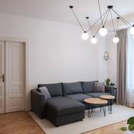 Interiér obývací části pokoje je zařízený čistě a minimalisticky.