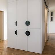 Úložné prostory se nacházejí ve vestavěné skříni. Zajímavým prvkem jsou vyfrézované půlkruhové otvory.