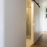 Bílá koupelna je určena pro běžný denní provoz. Pro úsporu místa jsou v ní posuvné dveře.