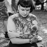 Jedna z návštěvnic festivalu vystavuje své impozantní tetování.