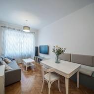 Úložný prostor táhnoucí se podél celé pravé stěny slouží zároveň jako lavice u jídelního stolu.