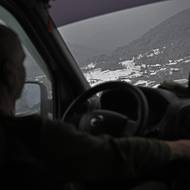 Valerij Popovyč za volantem svého bílého Nissanu projíždí zasněženými karpatskými vesničkami.