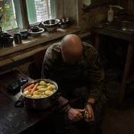 Při krátkém odpočinku na základně dvacet kilometrů od fronty připravuje Zachar oběd pro své kamarády.