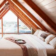 Prosklená štítová strana domu umožňuje výhled a spoustu světla i v ložnici umístěné v podkroví.