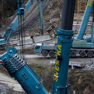 Materiál snáší do údolí autojeřáby. 