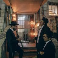 Chanuka v ortodoxní čtvrti Mea Šearim. U ulicích se hraje, tančí, zapalují se svíčky, kolemjdoucí se často spontánně přidávají. 