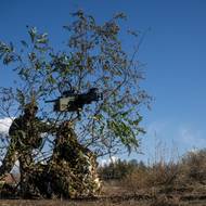 Voják 1039. pluku bezpilotních systémů Ozbrojených sil Ukrajiny maskuje americký kulomet Browning ráže .50, tak aby byl připraven k okamžitému zásahu proti ruským dronům. Palné zbraně – kulomety, útočné pušky a brokovnice – zůstávají účinnými prostředky při ochraně Ukrajiny před ruskými drony. Fotografie pořízena na Donbase 26. října 2025.