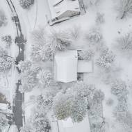 Dronový záběr odhaluje umístění chaty na pozemku u silnice.