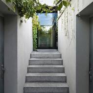 Prosklení křídla dveří prosvětlilo chodbu za nimi.