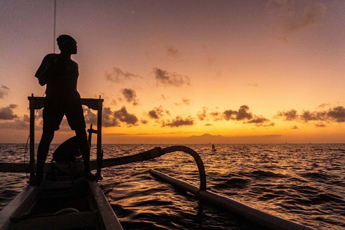 Ranní rybaření u ostrova Bali. V dáli silueta druhé nejvyšší indonéské sopky Rinjani na ostrově Lombok.
