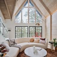 Zvenčí působí chata velmi tradičně a tak trochu tmavě. V interiéru pak ale překvapí prosklenou stěnou hlavního obývacího pokoje.