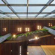 Ve vstupní hale architekti pracovali s různorodými materiály, jako s betonovými sloupy, dřevěnými panely, skleněnou fasádou či s rostlinami.