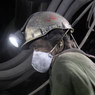 Před všudypřítomným prachem se někteří horníci brání respirátorem. 