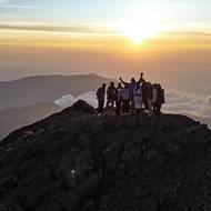 Skupinka turistů na vrcholu Mount Rinjani při východu slunce