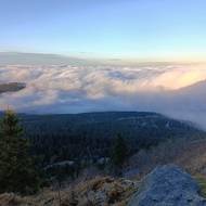 Odpolední slunce promítá siluetu Ještědu do vrstvy mlhy.