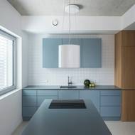 Bílá výmalba a modré a žluté odstíny nábytku jsou doplněné přiznanými železobetonovými stropy.