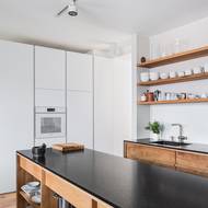 V kuchyni je možné obdivovat zábavnou kombinaci bílé, černé a přírodního dřeva.