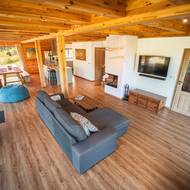 Otevřený koncept propojuje obývací pokoj, jídelnu i kuchyň v jeden celek. Díky dřevu a velkým oknům působí prostor útulně a svěže zároveň.