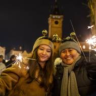 Silvestrovská atmosféra v historických ulicích Prahy krátce po půlnoci.