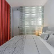 Denní světlo z oken ložnice propouští luxferová stěna dále do koupelny.