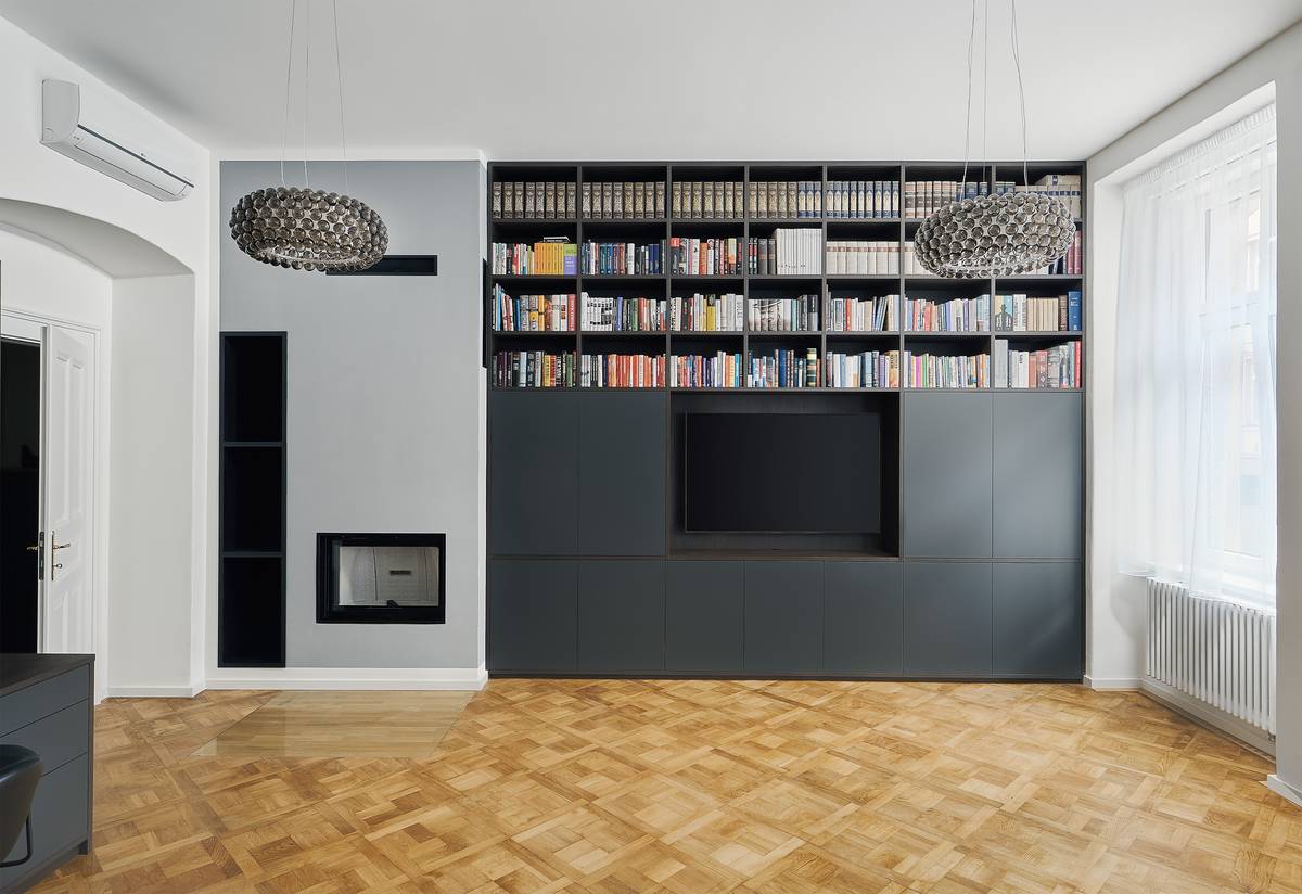 Knihovny sahají až pod 3,4 m vysoký strop. Dostat se k nim dá po schodech, které jsou schované v úložném prostoru v předsíni.