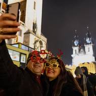 Skupiny přátel slaví přelom roku v centru města.