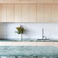 Za pracovní deskou je zeď obložena nenápadnými bílými obklady.