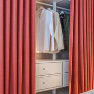Otevřenou šatnu halí závěs v terakotovém odstínu.