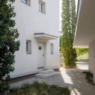 Hlavnímu vchodu do domu vévodí bílá barva a detail na dveřích v nautickém stylu. 