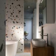 Koupelnu krášlí obklad inspirovaný terazzem. 