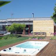 Do rozšířené terasy před domem je nově zakomponovaný bazén s protiproudem a vířivkou.