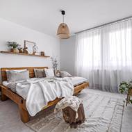 Středobodem ložnice je postel vyrobená z masivních dřevěných trámů, kterou si majitelé velmi chválí.