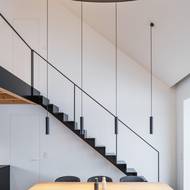 Černá barva pronikla i do interiérového vybavení – černá jsou svítidla, schody i židle u jídelního stolu.