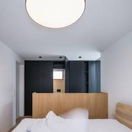 V ložnicích se opakuje motiv černého odstínu v kombinaci s přírodním dřevem.