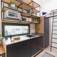 Černé skříňky jsou elegantním kontrastem ke světle laděnému interiéru.