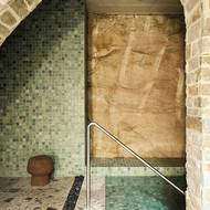 Místnost s bazénem má až mystickou atmosféru. Vedle zdobné mozaiky je vidět i kus pískovcové stěny, do které byla všechna podzemní patra vyhloubena. 