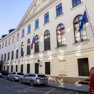 Na budově Poslanecké Sněmovny jsou vlajky Česka a EU, třetí sloupek je aktuálně prázdný. 