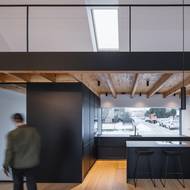 Nad obytným prostorem se otevírá vysoký strop, který dal vzniknout pochozí galerii nad kuchyní.