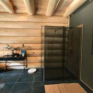 Sprchový kout je oddělený od kuláčů prosklenou stěnou.