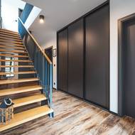 Vstupní hala propojuje přízemí s patrem pomocí otevřeného schodiště, které podporuje vzdušnost interiéru.