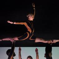 Akrobaté vystupují v jednoduchých kostýmech.