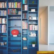 Červená svítidla zakomponovaná do knihovny tyrkysový prvek ještě více ozvláštňují a rozveselují.