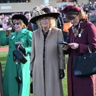 Královna Camilla na sobě měla stylový klobouk předního modisty Philipa Treacyho a kabát od britské módní návrhářky Anny Valentine doplněný stylovými koženými rukavičkami a semišovými kozačkami.