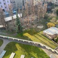 Společný dvůr s dětským hřištěm, bývalým tenisovým kurtem a pásy prosvětlující podzemní garáže.